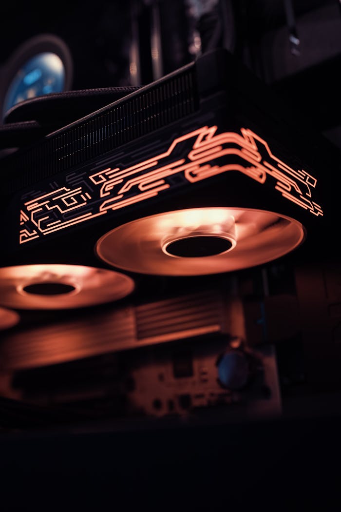 Stylish gaming computer with glowing cooling fans in low light, showcasing modern technology.